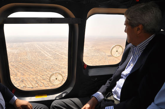 <i>US Secretary of State John Kerry views the Mrajeeb al-Fhood camp for Syrian refugees, 2014</i>. Photograph by US Department of State / Wikimedia Commons